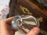 a person holding a glass in their hand in front of a dresser