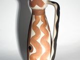 a brown and white vase sitting on a white surface