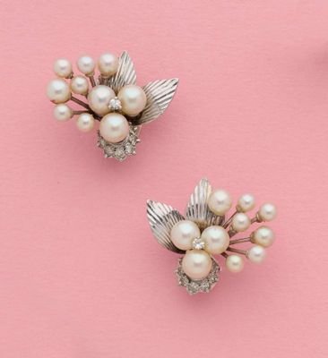 une paire de broches en forme de fleurs, en perles et en argent, sur fond rose