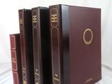 four books are lined up in a row on a white surface