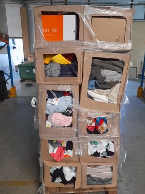 un carton de vêtements dans un entrepôt rempli de cartons