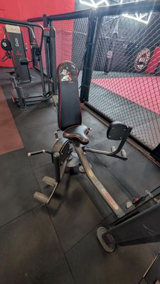 gym equipment in a gym with a cage in the background