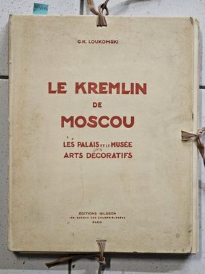 an old book is hanging on a wall with scissors