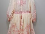 pink and white dress hanging on a hanger on a wall
