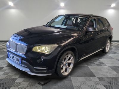 une photo d'un SUV BMW noir garé dans un showroom