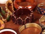 many different types of bracelets and rings on a table