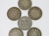 six different coins are arranged in a circle on a white surface