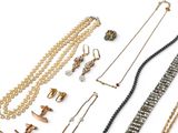 many different types of necklaces and bracelets on the table