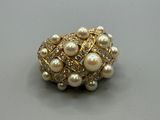 bague en perle et or sertie de diamants sur un fond gris