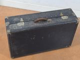 a black suitcase sitting on the floor next to a white wall