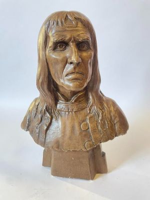 un gros plan d'un buste de femme en bronze sur fond blanc