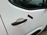 a white car with a black door handle and a sticker on it