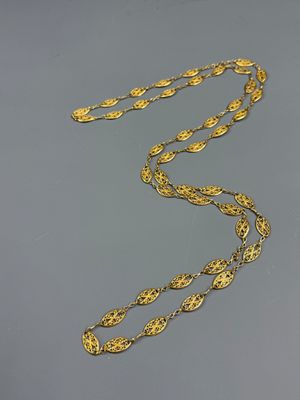 a close up of a gold necklace on a gray surface