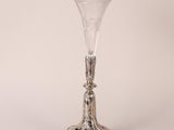un vase ancien en verre plaqué argent, posé sur un socle, sur fond blanc