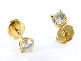 two pairs of diamond stud earrings on a white surface