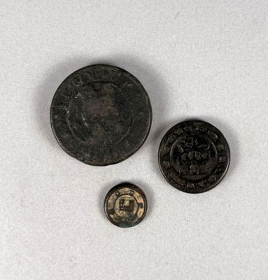 une vieille pièce et une petite pièce posées sur une surface blanche