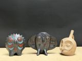 trois figurines d'oiseaux en céramique et un vase posés sur une table