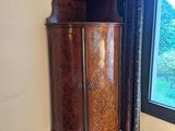 a tall wooden cabinet in the corner of a room