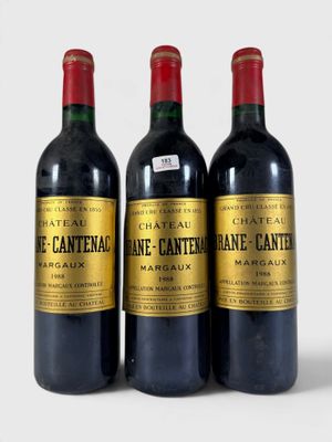 trois bouteilles de vin rouge posées l'une à côté de l'autre sur une surface blanche
