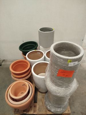 de nombreux pots en terre cuite sur une palette dans un entrepôt