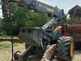 un tracteur qui est à l'arrêt dans la terre, près d'un camion