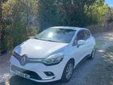 a white car parked on the side of a dirt road