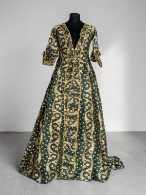 une robe en soie verte et dorée, à encolure en V et à manches longues
