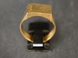 gros plan d'une bague en or sur une surface noire