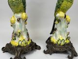pair of green and yellow parrots sitting on a tree stump