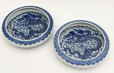 deux assiettes bleues et blanches ornées de motifs de dragons sur fond blanc