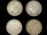 four different types of silver coins on a black background