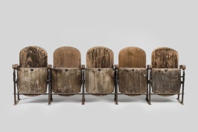 four wooden chairs sitting on top of each other in front of a gray background