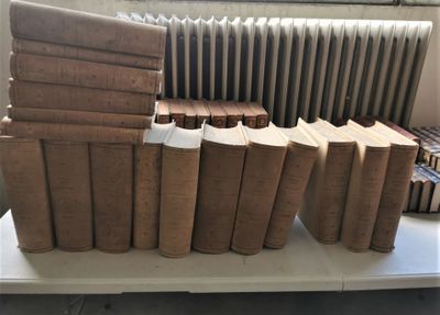 de nombreux livres empilés sur une table devant un radiateur