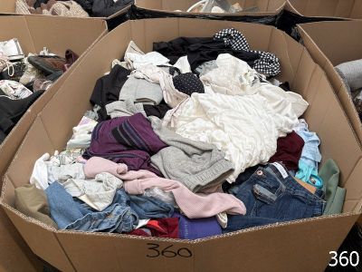 a cardboard box full of clothes in a room