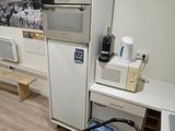 une petite cuisine équipée d'un réfrigérateur, d'un micro-ondes et d'autres appareils électroménagers