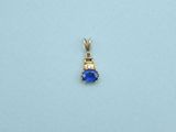 a close up of a small blue stone pendant on a white surface