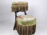 une image représentant une chaise avec un repose-pieds et un tabouret sur lequel est posé un coussin