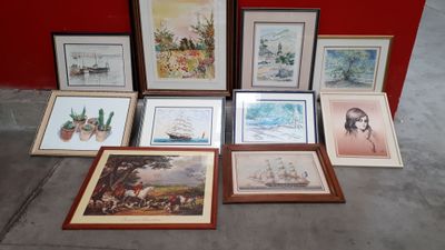 a lot of framed pictures on the floor next to a red wall