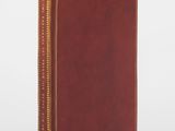 un livre marron avec une bordure dorée et une couverture rouge