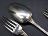 two forks and a spoon sitting on a table