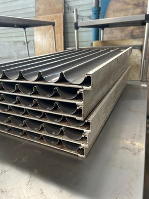 une pile de tuyaux en acier posée sur une table en métal