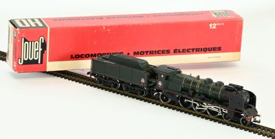 un petit train qui se trouve sur les rails, à côté d'une boîte