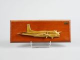 une boîte en bois sur laquelle est représenté un avion doré
