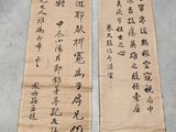 deux calligraphies chinoises posées sur une table, à côté d'une paire de ciseaux