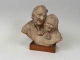 statue représentant un homme et un enfant, posée sur un socle en bois