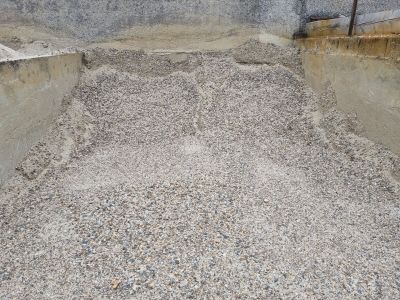 un gros tas de gravier au milieu d'un mur en béton