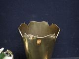 a gold vase sitting next to a green vase on a table