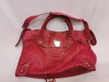 a red purse with a tag on it sitting on a white surface
