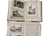 three open books with pictures of buildings on them on a white surface