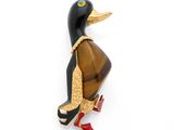 une broche en forme de canard noir et doré sur fond blanc
